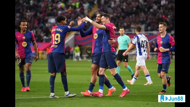 Cầu thủ Barca đi bóng qua cầu thủ của Real Sociedad trong trận đấu sôi động